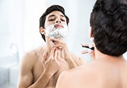 man shaving in mirror